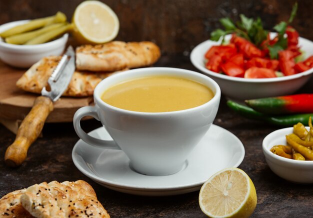 Soupe aux lentilles servie dans une tasse avec du citron