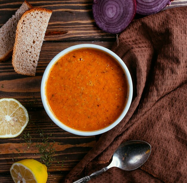 Soupe aux lentilles avec une tranche de citron vue de dessus sur une table