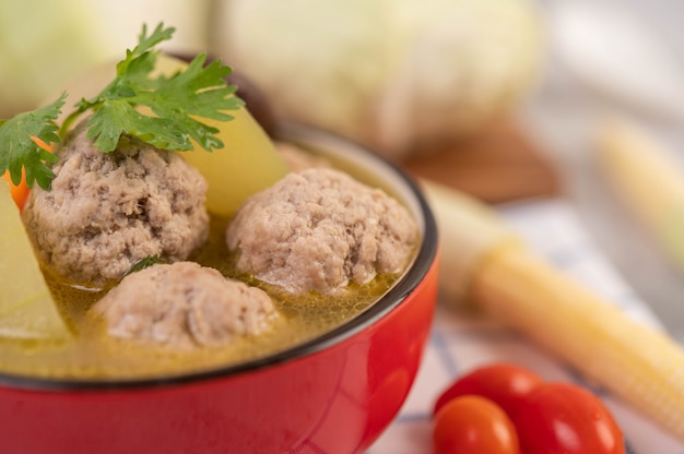 Soupe de boule de porc dans une tasse sur un tissu bleu-blanc.