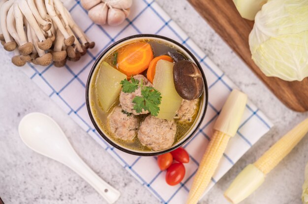 Soupe de boule de porc dans une tasse sur un tissu bleu-blanc.