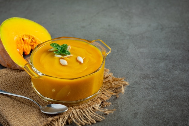 Soupe à la citrouille dans un bol en verre place sur un sac en tissu