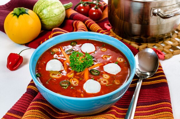 Soupe épicée aux tomates pimentées avec des boules de crème sure dans un bol