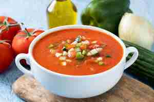 Photo gratuite soupe de gaspacho espagnol traditionnel dans un bol sur fond bleu