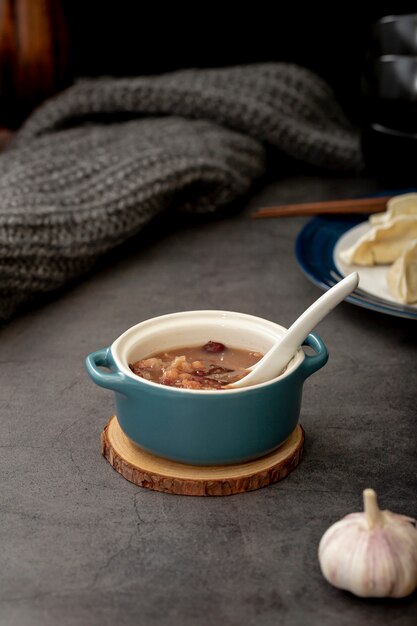 Soupe de haricots dans un bocal bleu à l'ail sur fond gris