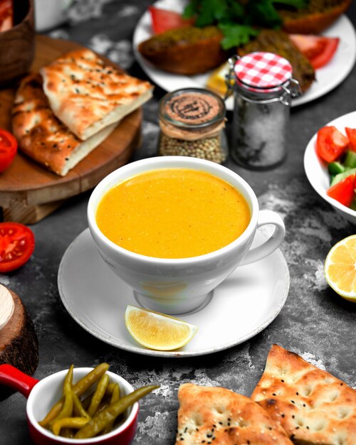 Photo gratuite soupe de lentilles dans une tasse servie avec du citron