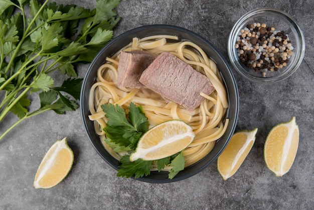 Soupe de pâtes au boeuf avec des tranches de citron et de persil