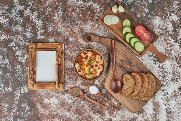 Soupe de pâtes avec un plateau de légumes autour