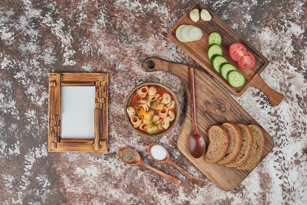 Soupe de pâtes avec un plateau de légumes autour