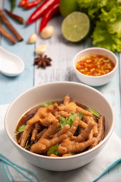 Soupe de pieds de poulet ragoût servie avec sauce de poisson épicée