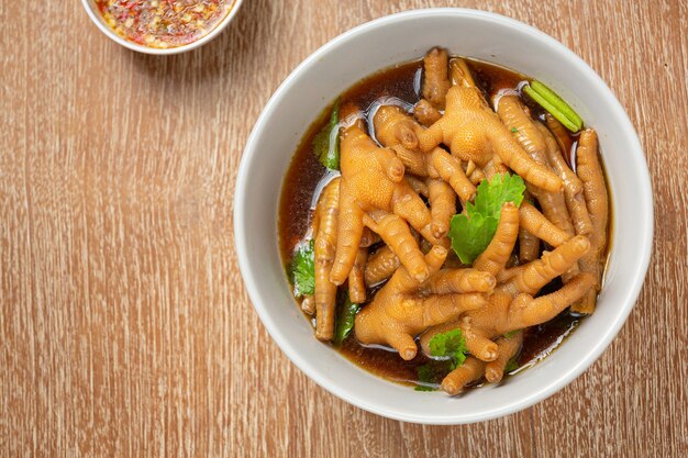 Soupe de pieds de poulet ragoût servie avec sauce de poisson épicée