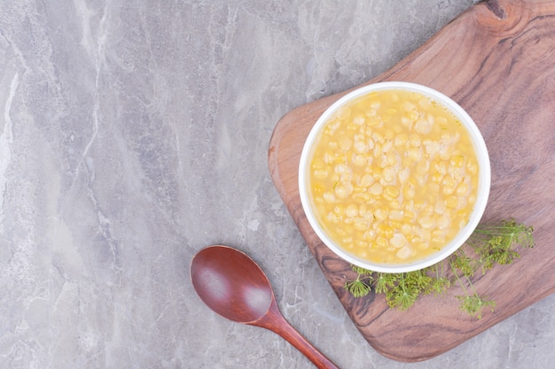 Soupe de pois jaunes dans une assiette blanche sur la planche de bois