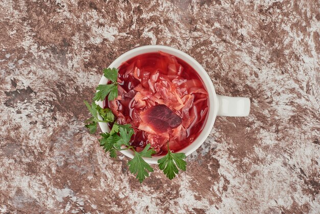 Soupe rouge aux herbes servie avec du pain.