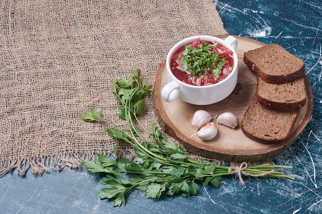 Soupe rouge aux herbes et tranches de pain.