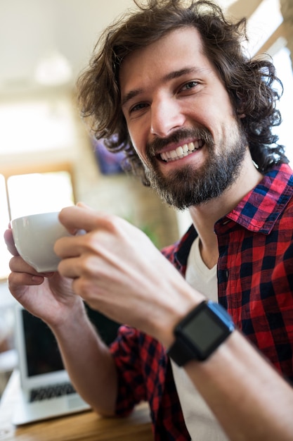 Photo gratuite souriant acup de café homme de dans le café