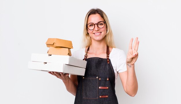 Souriant et amical montrant le numéro trois