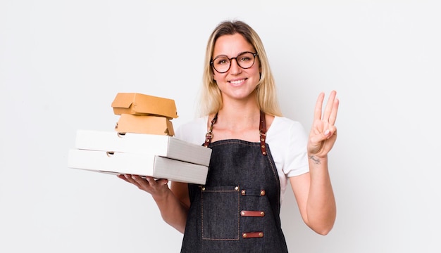 Souriant et amical montrant le numéro trois