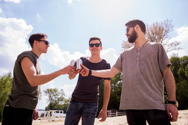 Souriant amis applaudissant avec de la bière