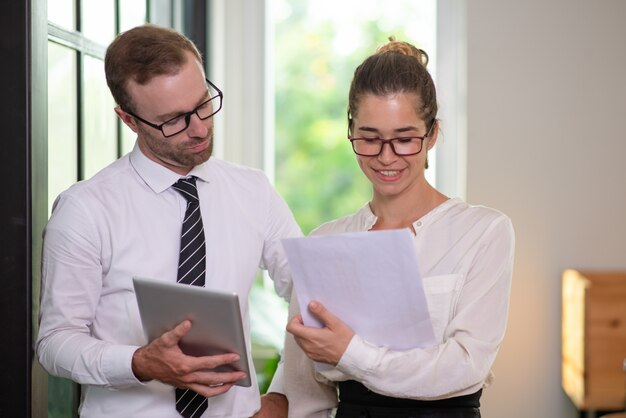 Souriant collègues travaillant avec le document.