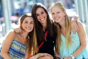 Photo gratuite souriant femmes étreignant tout en restant assis sur le banc