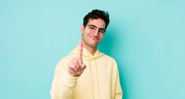 souriant fièrement et avec confiance en faisant la pose numéro un se sentant triomphalement comme un leader