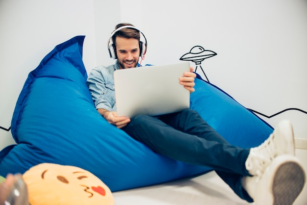 souriant homme avec un casque et un ordinateur portable