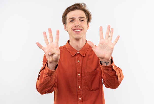 Souriant jeune beau mec vêtu d'une chemise rouge montrant différents numéros