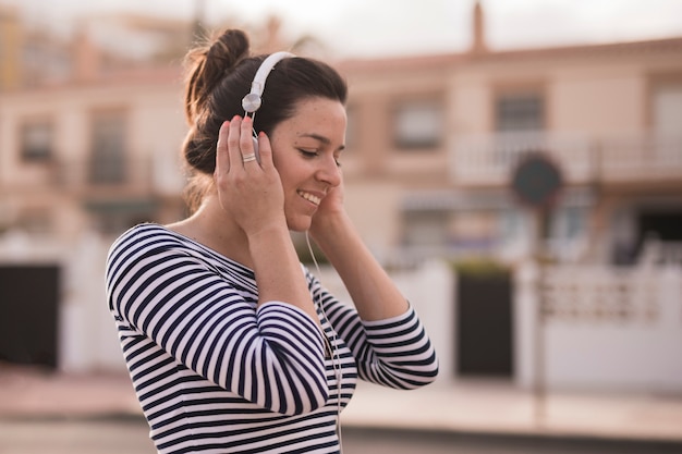 Photo gratuite souriant jeune femme écoutant de la musique sur le casque