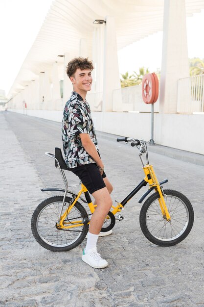 Souriant jeune homme assis à vélo