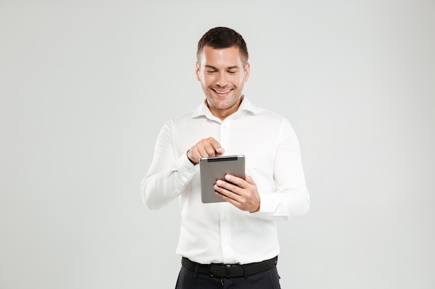 Souriant jeune homme bavardant par ordinateur tablette.