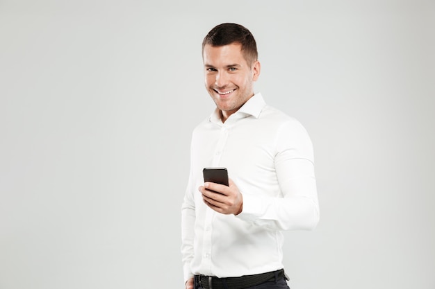 Souriant jeune homme bavardant par téléphone.