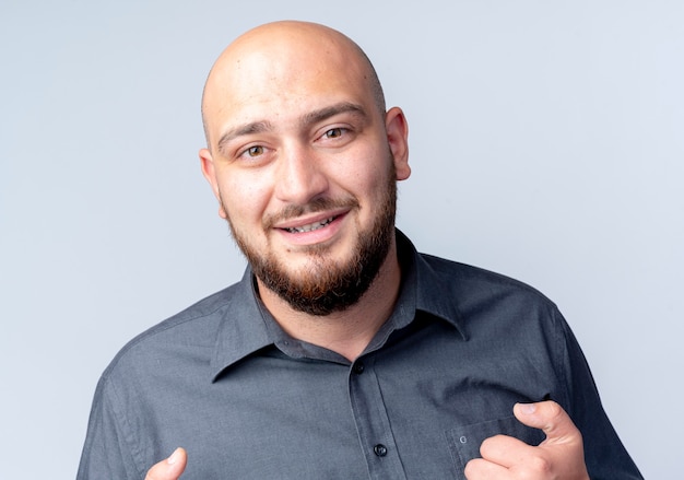 Photo gratuite souriant jeune homme de centre d'appels chauve regardant avant isolé sur mur blanc