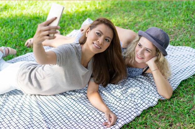 Souriant jeunes femmes multiethniques reposant sur une couverture