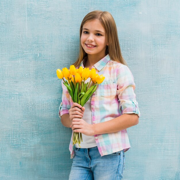 Souriant portrait d&#39;une fille blonde tenant des tulipes dans la main à la recherche d&#39;appareil photo