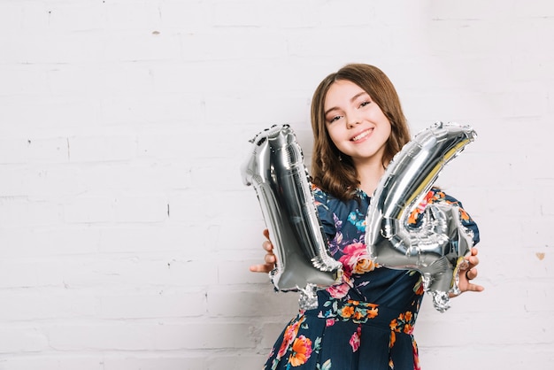 Souriant Portrait D'une Jeune Fille Montrant Le Ballon En Feuille Numéro 14