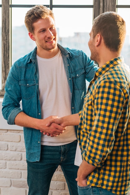 Photo gratuite souriant portrait d'un jeune homme se serrant la main