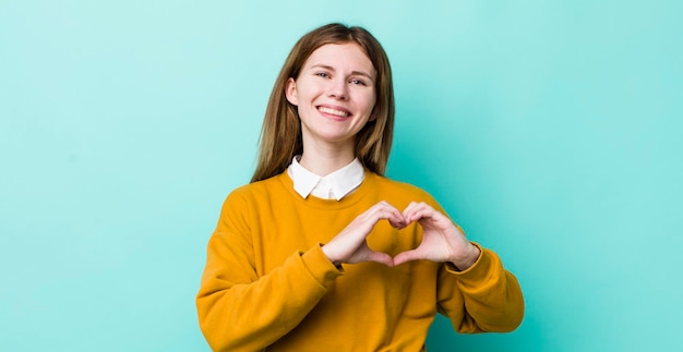 souriant et se sentir heureux mignon romantique et amoureux en forme de coeur avec les deux mains