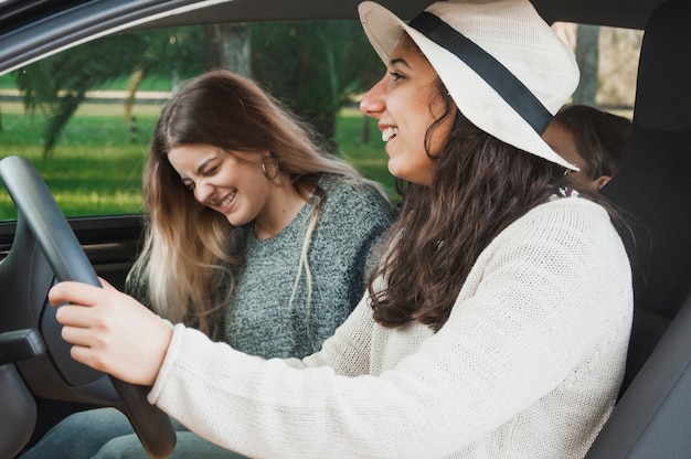 Souriant soeurs assis à l&#39;intérieur de la voiture