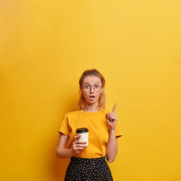 Souriante belle jeune femme étonnée