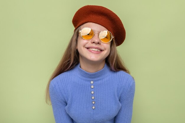 Souriante belle petite fille portant un chapeau avec des lunettes