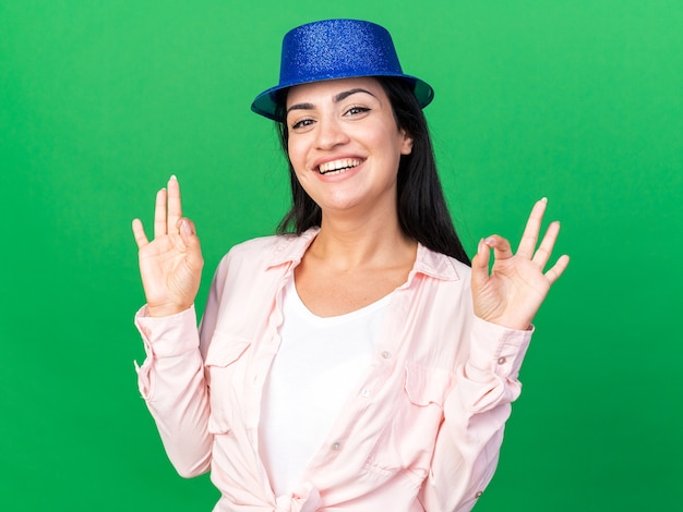 Photo gratuite souriante jeune belle fille portant un chapeau de fête montrant un geste correct