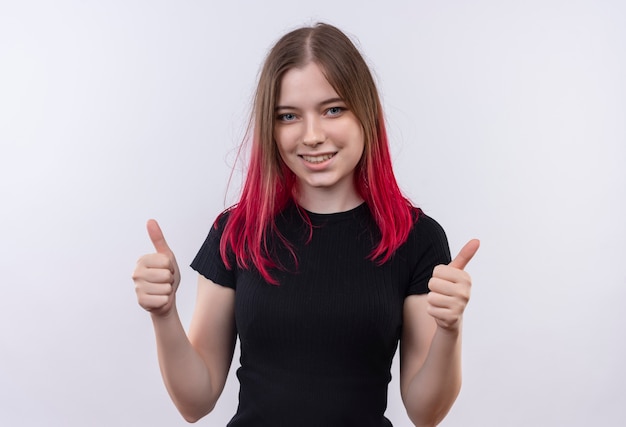 Souriante jeune belle fille portant un t-shirt noir ses pouces vers le haut sur fond blanc isolé