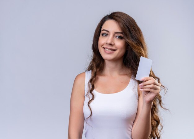 Souriante jeune belle fille tenant une carte de crédit avec espace copie