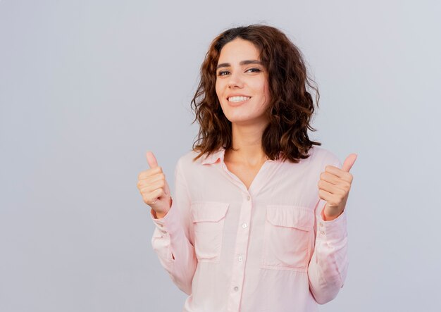 Souriante jeune femme caucasienne pouces vers le haut avec deux mains