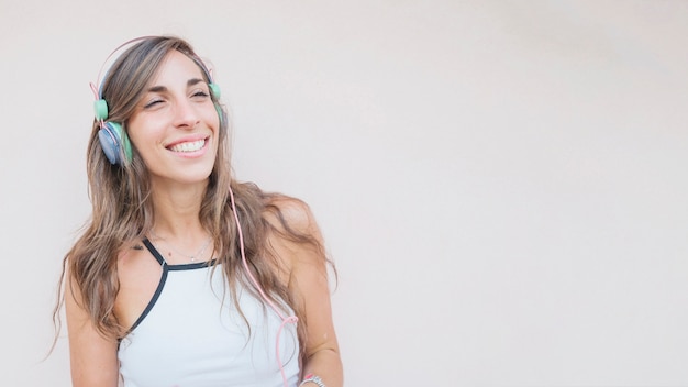 Souriante Jeune Femme écoutant De La Musique Sur Le Casque Sur Fond Coloré