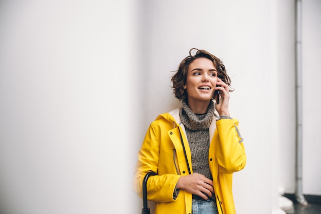 Souriante jeune femme habillée en imperméable