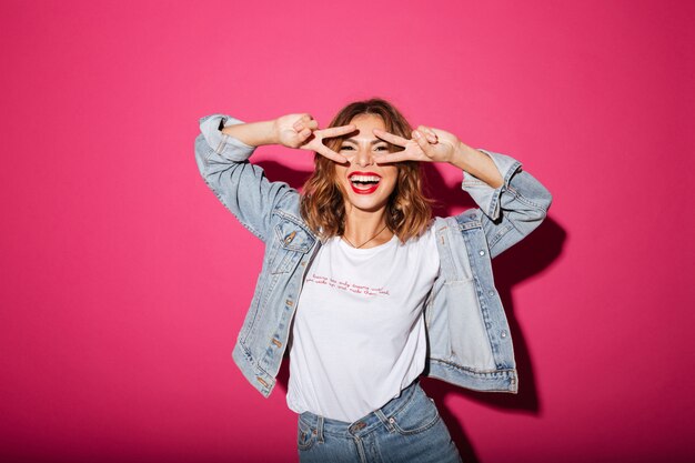 Souriante jeune femme isolée sur rose