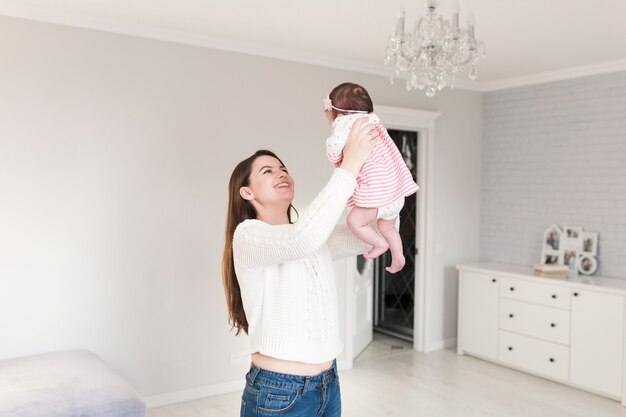 Souriante jeune femme jouant avec un enfant