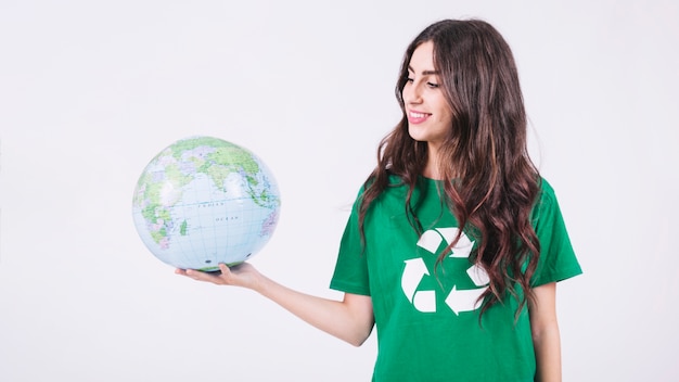 Souriante jeune femme regardant le globe