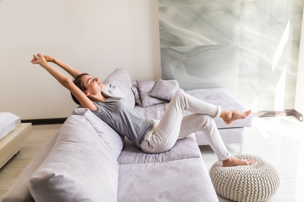 Photo gratuite souriante jeune femme se détendre allongé sur le canapé