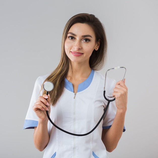 Souriante jeune femme tenant un stéthoscope